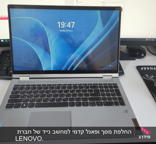 מחשב נייד לנובו על שולחן עם מסך נוסף ועכבר לוג